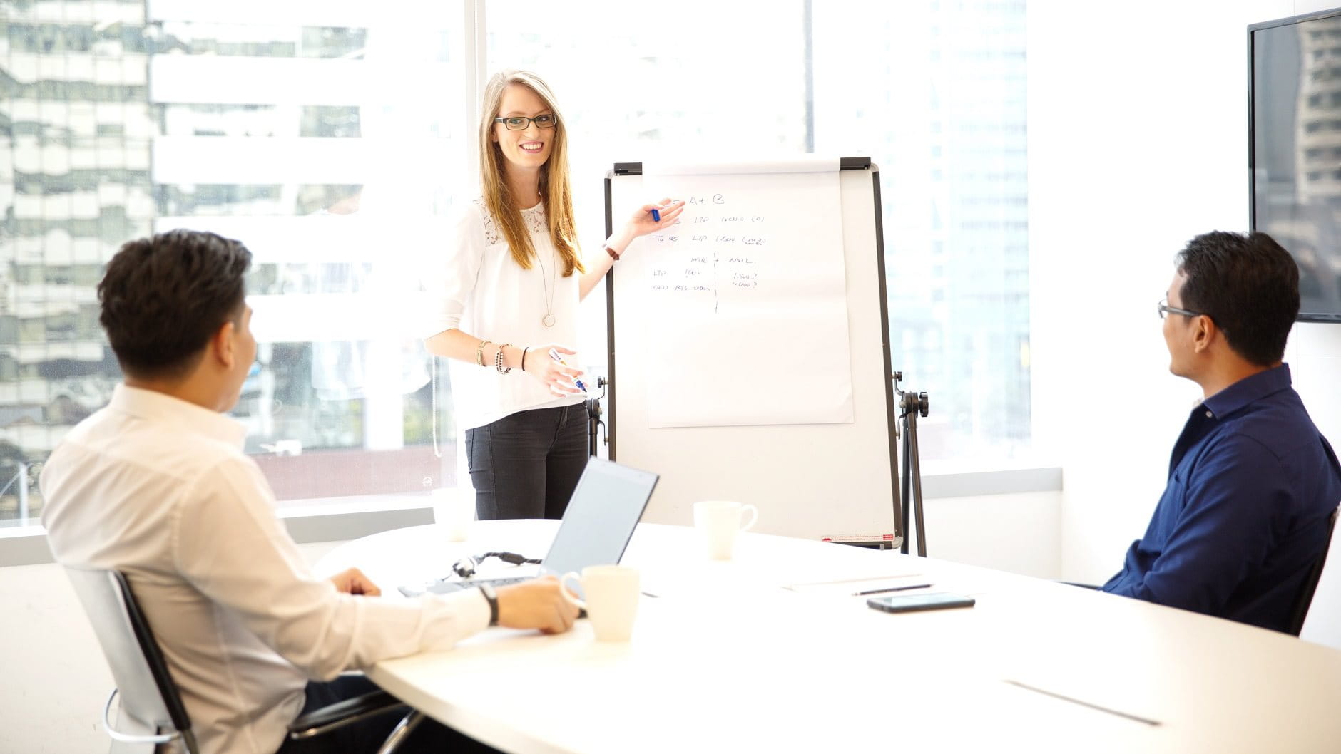 Learning and Development Beiersdorf Thailand, employees working together in office, women pointing to flipchart